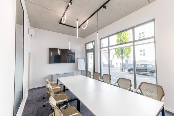 Moderner Konferenzraum von Ganter Nachfolge mit Tageslicht und reduzierter Einrichtung